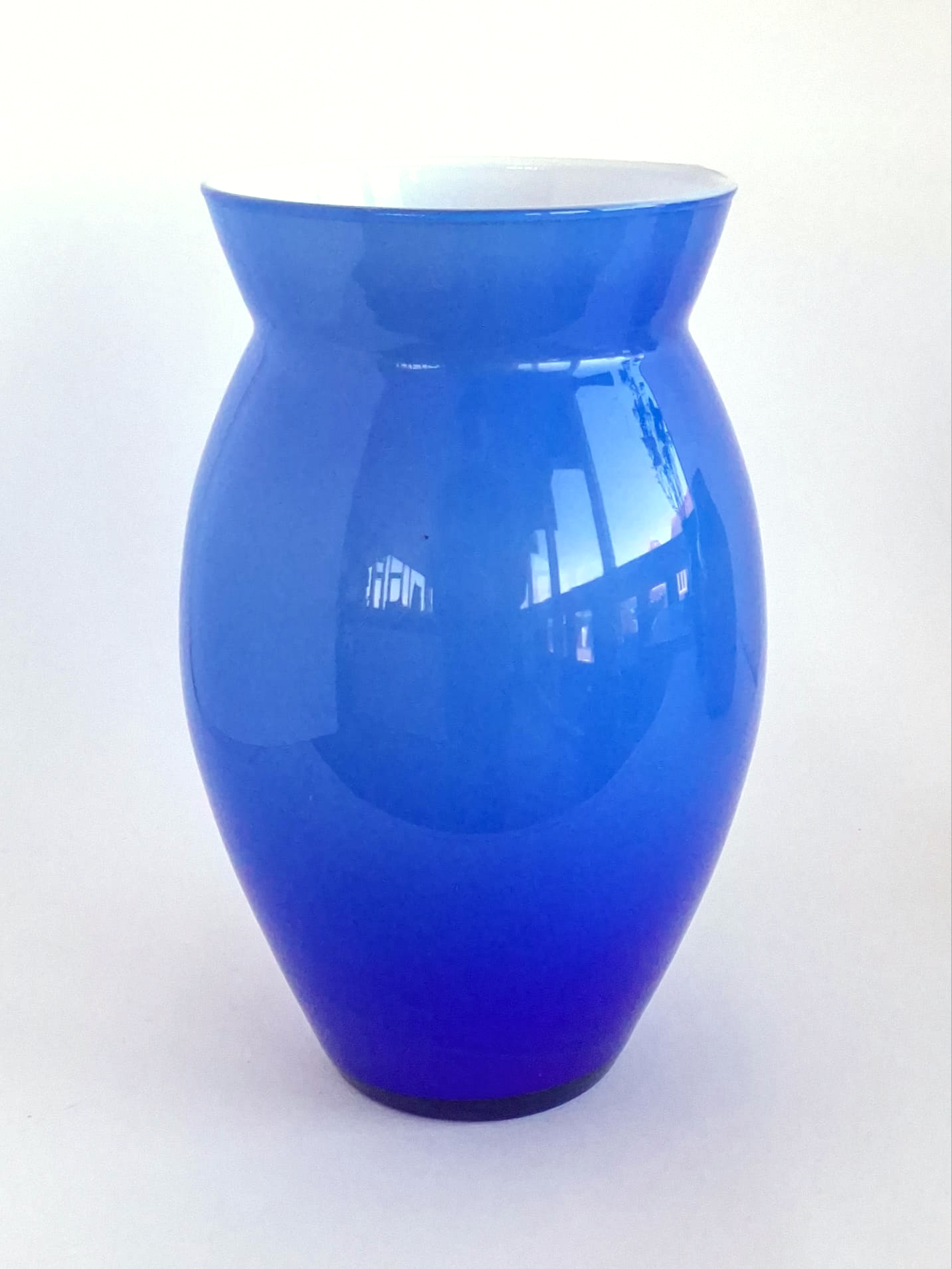 Blue cased glass vase with white interior