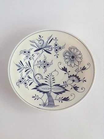 White porcelain saucer with blue Zwiebelmuster onion pattern featuring stylized flowers and foliage