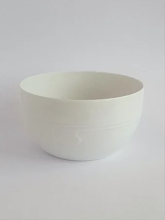 Minimalist white porcelain bowl with clean modern lines and subtle horizontal groove detail