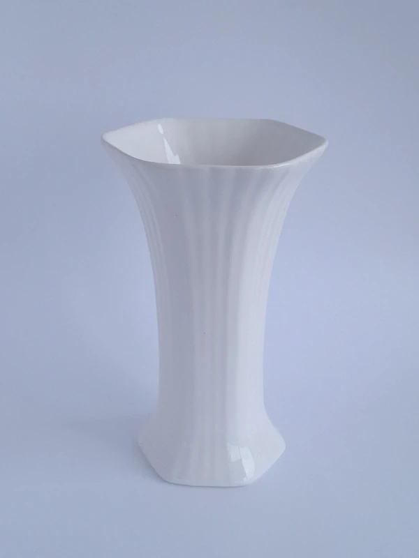 White glazed hexagonal vase with flared rim and vertical ribbed body