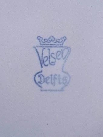 Blue stamped mark showing Velsen written inside a vase outline with crown, and Delfts below